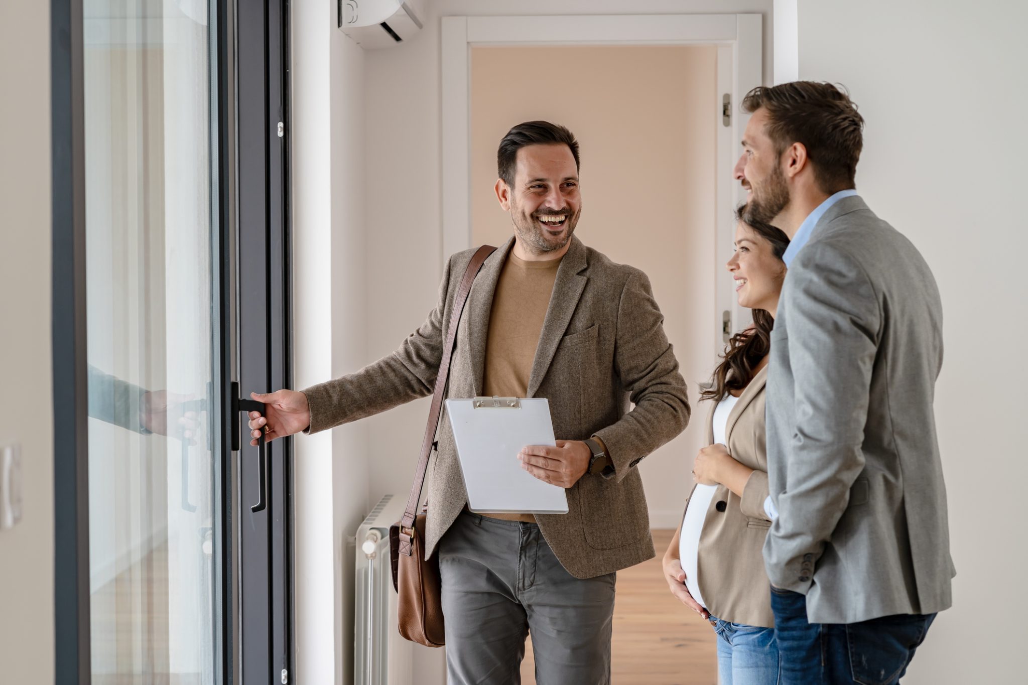 Couple touring a house with a real estate agent.